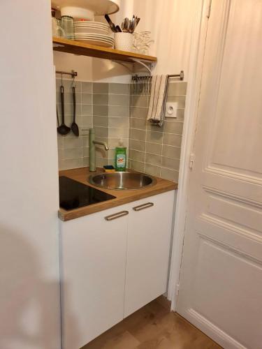 une petite cuisine avec un évier et un comptoir dans l'établissement Home Sweet Home Sacré-Coeur Montmartre, à Paris