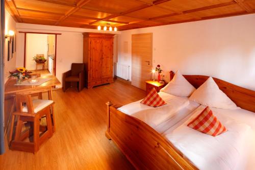een slaapkamer met een groot houten bed met kussens bij Gaisbock der DorfUrlaub in Fischen