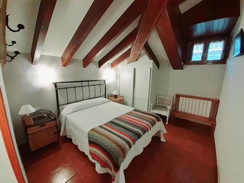 a bedroom with a bed and a wooden floor at La Casona del Jou in Ortiguero