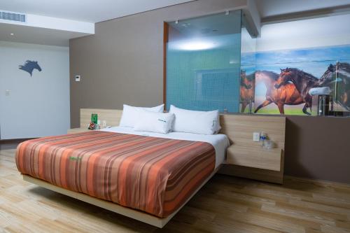 a bedroom with a bed with a painting of a horse on the wall at Hotel Xcoco Inn in Texcoco de Mora