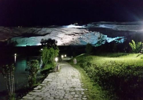 a stone path at night with a snow covered mountain at Hotel Pamukkale in Pamukkale