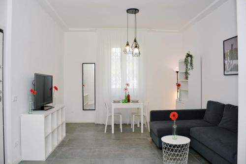 - un salon avec un canapé et une télévision dans l'établissement Florence Chic, garden and parking, à Florence