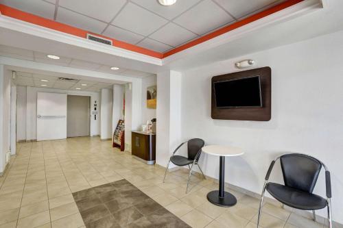 a hallway with chairs and a table and a tv at Motel 6-Lemoore, CA in Lemoore