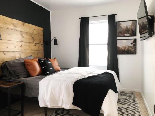 a bedroom with a black and white bed and a window at the218 on 7th in Grand Rapids