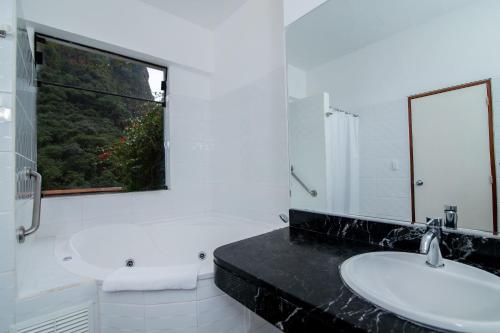 La salle de bains est pourvue de 2 lavabos et d'une fenêtre. dans l'établissement Tierra Viva Machu Picchu Hotel, à Machu Picchu