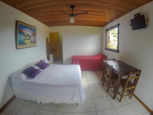 a bedroom with a bed and a desk and a table at Topo do Cipó Ecopousada Vegana in Serra do Cipo