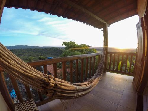 a hammock on a balcony with a view at Topo do Cipó Ecopousada Vegana in Serra do Cipo