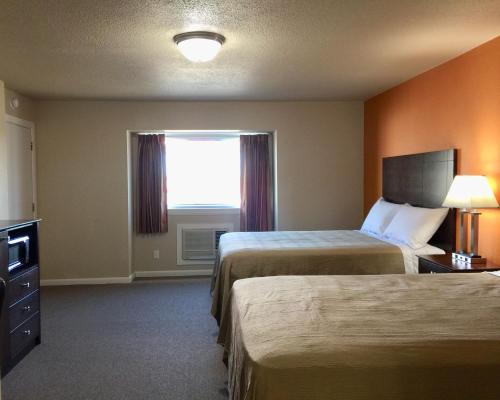 una camera d'albergo con due letti e una finestra di Downtown Motel Woodward a Woodward