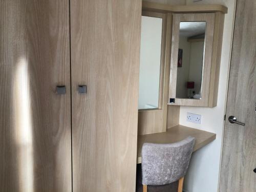 Zimmer mit einem Schreibtisch und einem Schrank mit einem Spiegel in der Unterkunft Emmanuel Holiday Home in Whitley Bay