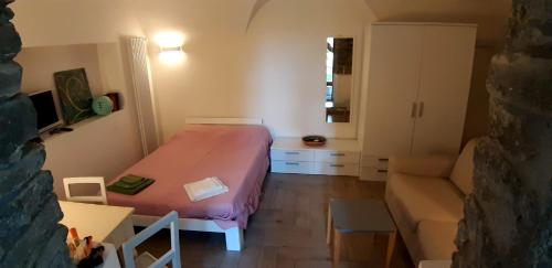ein kleines Zimmer mit einem Bett und einem Sofa in der Unterkunft Camelia in Premeno
