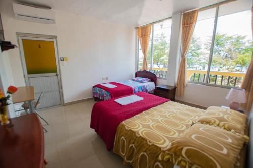 a hotel room with two beds and a window at HOSTAL SAN FRANCISCO in San Cristóbal