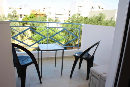 a balcony with two chairs and a table on a balcony at Veggie Garden Athens B&B in Athens