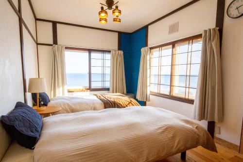 a bedroom with two beds and a view of the ocean at kODATEL コダテル函館オーシャン in Hakodate