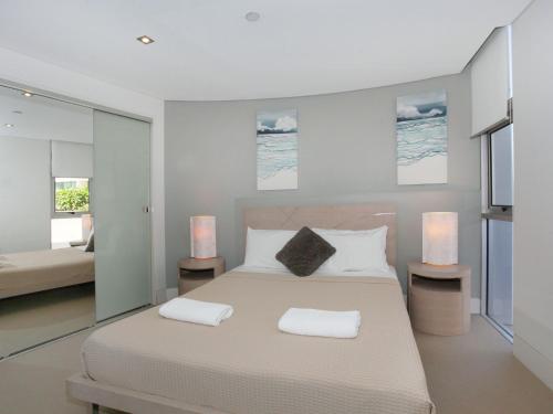 a bedroom with a large bed with two towels on it at Oceans 201 luxurious beachfront apartment in Mooloolaba
