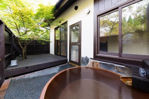 a large tub sitting on the outside of a house at Hanare no Yado Hanagokoro in Minamioguni