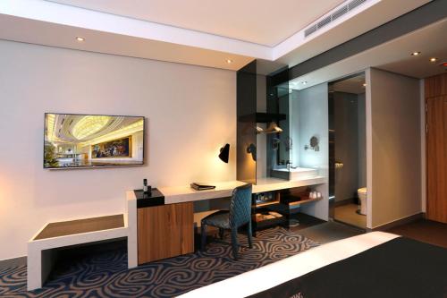 a hotel room with a desk and a sink at Golden Tulip - Aesthetics in Zhunan