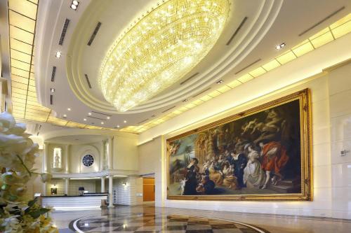 a large painting on the wall in a lobby with a chandelier at Golden Tulip - Aesthetics in Zhunan