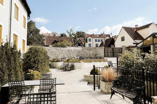 a patio with benches and a stone wall at Clarion Hotel Wisby in Visby