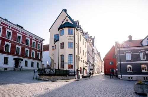 a building on a cobblestone street in a city at Clarion Hotel Wisby in Visby