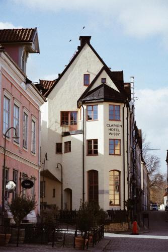 a white building with a sign on the side of it at Clarion Hotel Wisby in Visby