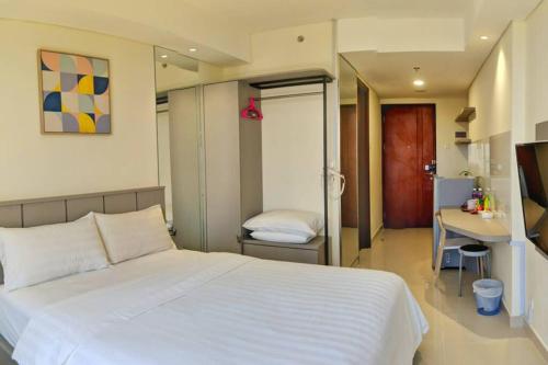 a bedroom with a large white bed and a desk at Lovina 1205 at Pollux Meisterstadt in Batam Center
