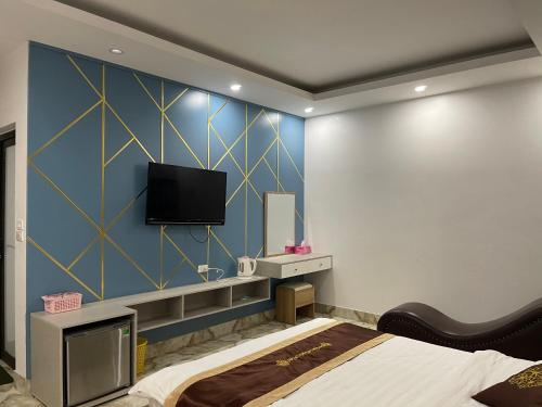 a bedroom with a bed and a flat screen tv at Ngoc Huyen Hotel in Tam Ðảo