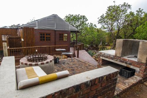 a backyard with a log cabin and a fire pit at Amafu Forest Lodge in Hoedspruit