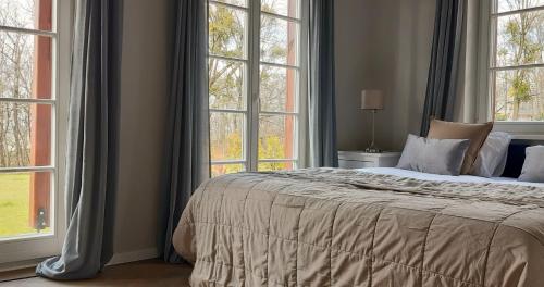 a bedroom with a large bed with windows at Zamkowe Wzgórze Dom Nr 3 Kazimierz Dolny, Góry in Kazimierz Dolny