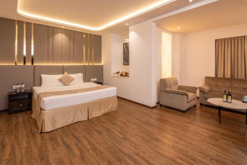 a hotel room with a bed and a chair at Goldfinch Hotel Bangalore in Bengaluru