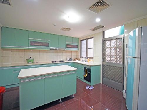 a kitchen with green cabinets and a refrigerator at 媽宮古街10號 in Magong