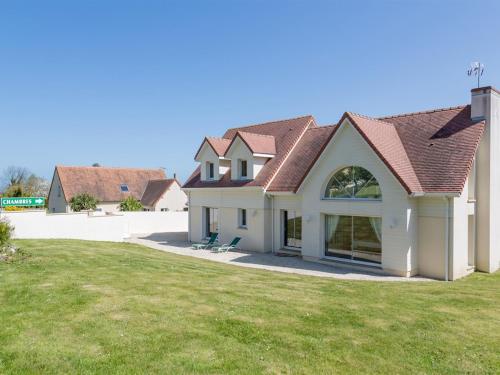 uma casa com um grande quintal com relva verde em Villa Tracy em Arromanches-les-Bains