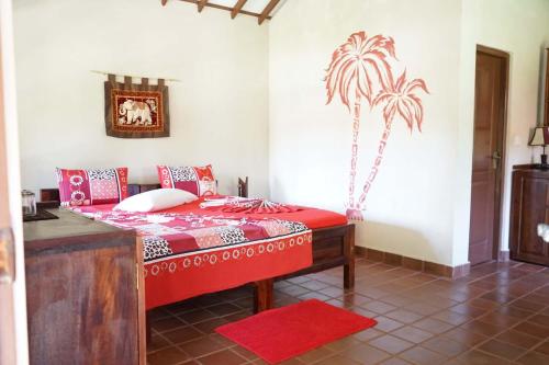 ein Schlafzimmer mit einem Bett mit einer Palme an der Wand in der Unterkunft Puetz Travels Beach Resort in Wayikkal