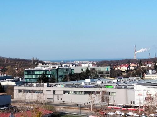 a large white building with a city in the background at WIDOK NA MORZE in Gdańsk