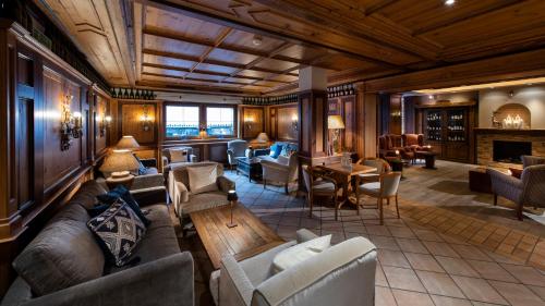 a living room with couches and chairs and a fireplace at MANNI das Hotel in Mayrhofen