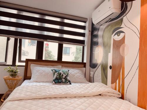a bedroom with a bed with a painting on the wall at HnH homestay in Hanoi