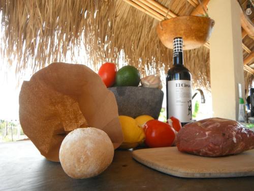 uma mesa com uma garrafa de vinho e algumas frutas em Room in Guest room - Camp - Santos Cabana Fabricio em Todos Santos