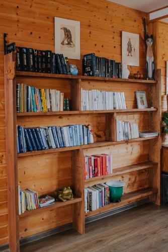 a library with wooden shelves filled with books at Dom Gościnny Sowia Stópka in Miłomłyn