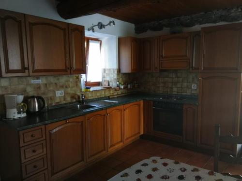 una cucina con armadi in legno, lavandino e finestra di Rustico Bietto a Cevio