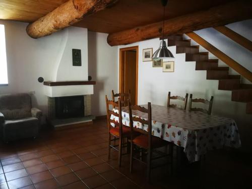 une salle à manger avec une table, des chaises et un escalier dans l'établissement Rustico Bietto, à Cevio