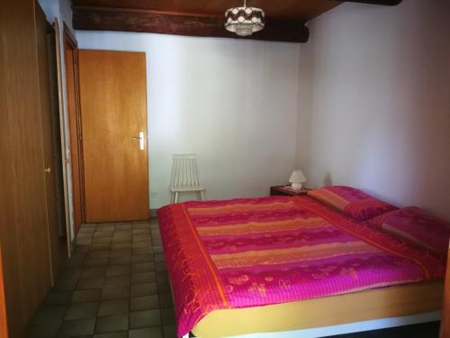 um quarto com uma cama grande e um cobertor vermelho em Rustico Bietto em Cevio