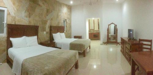 a hotel room with two beds and a mirror at Quinta Alberto Boutique Hotel in San Blas