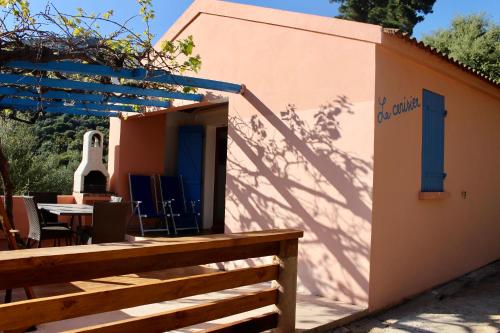 a house with a table and chairs and a fence at Résidence Itylon in Cargèse
