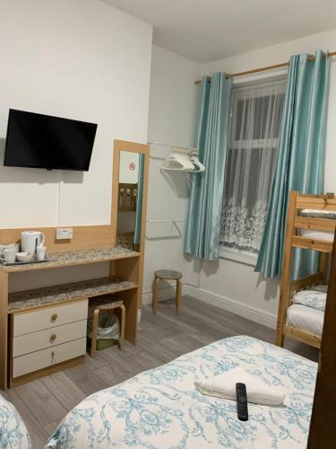 a room with a bed and a desk and a mirror at The Danescourt in Blackpool