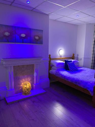 a purple room with two beds and a fireplace at The Danescourt in Blackpool