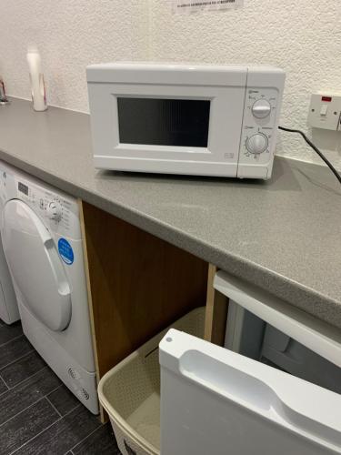a microwave sitting on a counter next to a dishwasher at The Danescourt in Blackpool