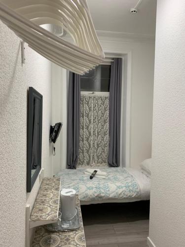 a small bedroom with a bed and a mirror at The Danescourt in Blackpool