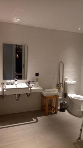 a bathroom with a sink and a toilet and a mirror at Greet Inn in Kaohsiung