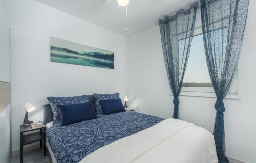 a bedroom with a blue and white bed and a window at Villa Pendolina with Private Pool in Buje