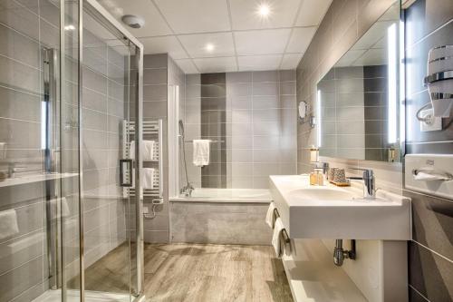 a bathroom with a sink and a shower at Mercure Cabourg Hôtel & Spa in Cabourg