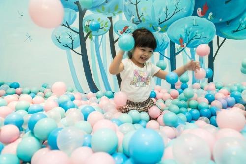 a little girl playing in a ball pit of balloons at Maia Resort Quy Nhon in Quy Nhon